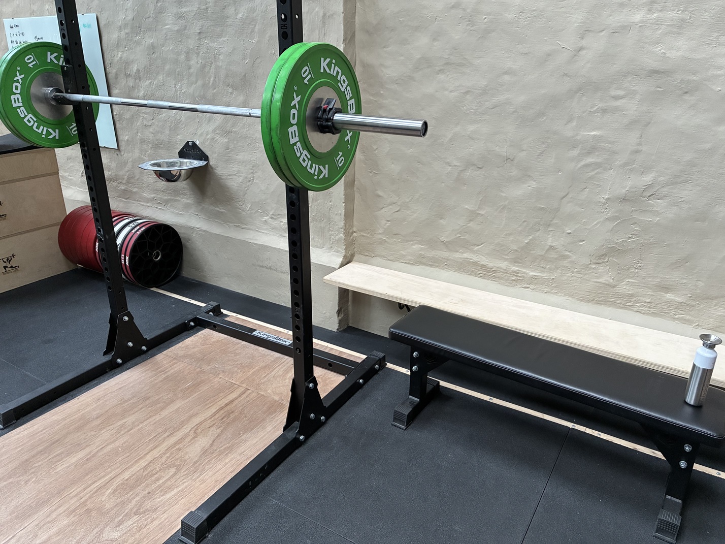 Squat rack met barbell en groene gewichtsschijven